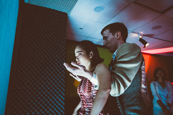 one actor holds the arms of an actress in a dark and cinematographic place